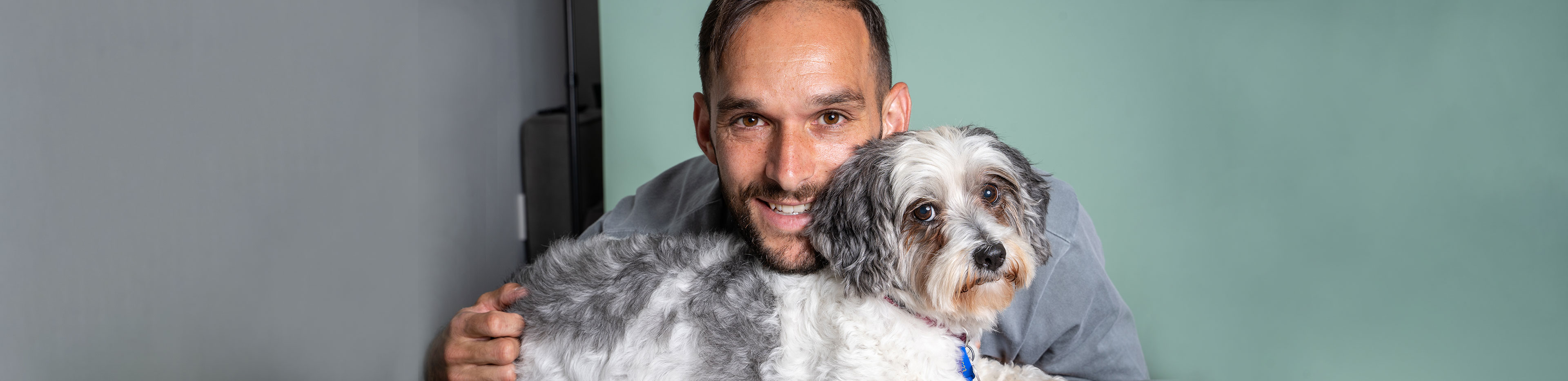 RSPCA Qld Ambassador Jack Hingert cuddles into his small rescue dog Chloe